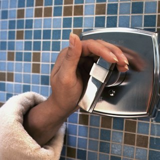 Hand pulling a fresh paper towel from a dispenser